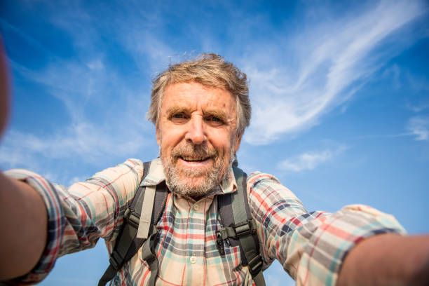 istock Senior Manon top of a Mountain taking a Selfie using Smartphone 1043579910