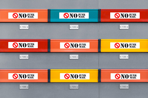 Multicolored modern mailboxes with no junk mail stickers on every box. Front view illustrative picture