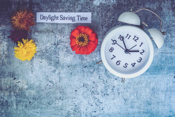 istock Fall Daylight Saving Time concept with white clock and flowers, flat lay 1043593356