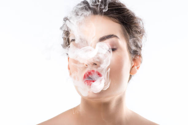 istock beautiful woman blowing smoke, isolated on white 1043608668