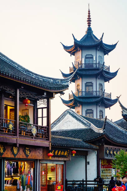 At the Zhouzhuang Water Town, Suzhou, China Suzhou, China - Nov 5, 2016: Shopping street at the historic Zhouzhuang Water Town. Image features a pagoda and shops designed in traditional Chinese architecture style. Visitors can be seen in the area. water town zhouzhuang china stock pictures, royalty-free photos & images