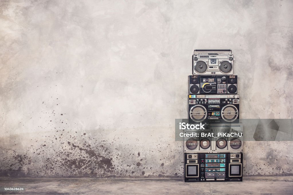 Retro old school design ghetto blaster boombox stereo radio cassette tape recorders tower from circa 1980s front concrete wall background. Vintage style filtered photo Backgrounds Stock Photo