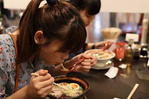 Two taiwanese enjoy eating Ramen noodles in Japan