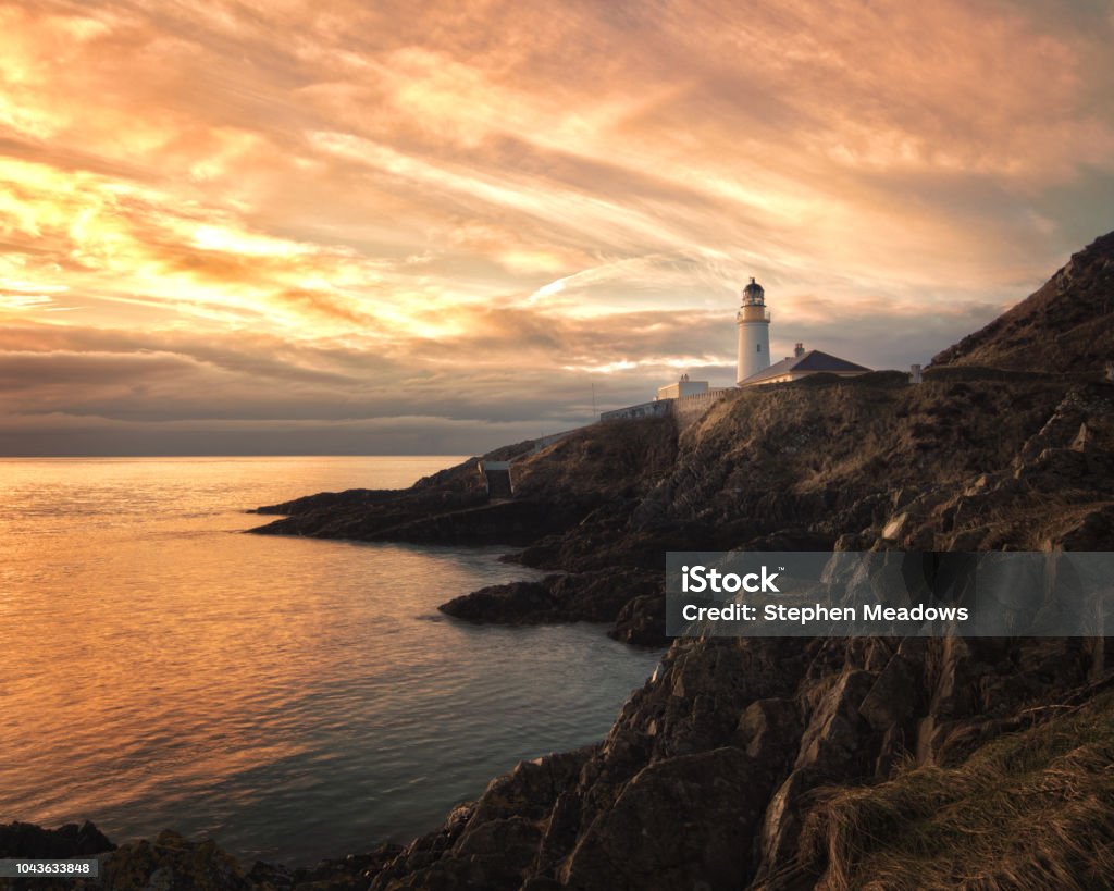 Sunrise at Douglas Lighthouse, Isle of Man Beautiful dramatic skies at sunrise over Douglas Lighthouse, Isle of Man, with high interesting cloud formation. Isle of Man Stock Photo