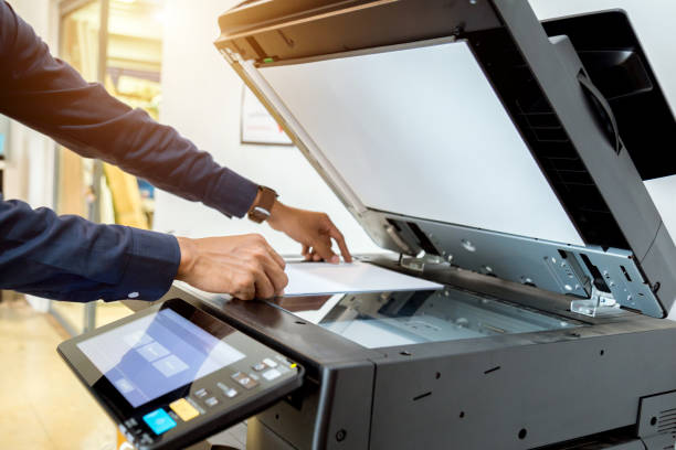 istock Bussiness man Hand press button on panel of printer, printer scanner laser office copy machine supplies start concept. 1043634042