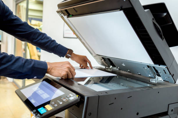 istock Bussiness man Hand press button on panel of printer, printer scanner laser office copy machine supplies start concept. 1043634102