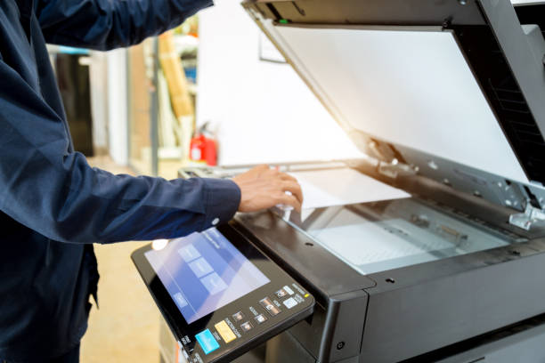 istock Bussiness man Hand press button on panel of printer, printer scanner laser office copy machine supplies start concept. 1043634232