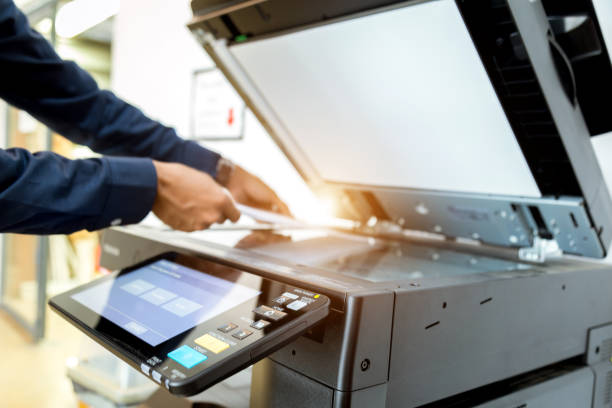 istock Bussiness man Hand press button on panel of printer, printer scanner laser office copy machine supplies start concept. 1043634252
