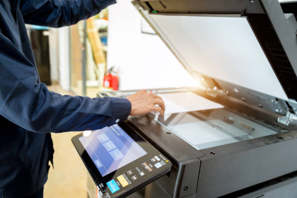 istock Bussiness man Hand press button on panel of printer, printer scanner laser office copy machine supplies start concept. 1043634290