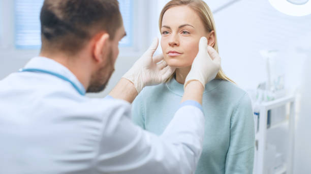 plastique / visage de femme beau examine chirurgien cosmétique, il touche avec les mains gantées, inspectant les visage guéri après chirurgie plastique avec des résultats étonnants. - plastic protective glove wrinkle treatment medical instrument photos et images de collection