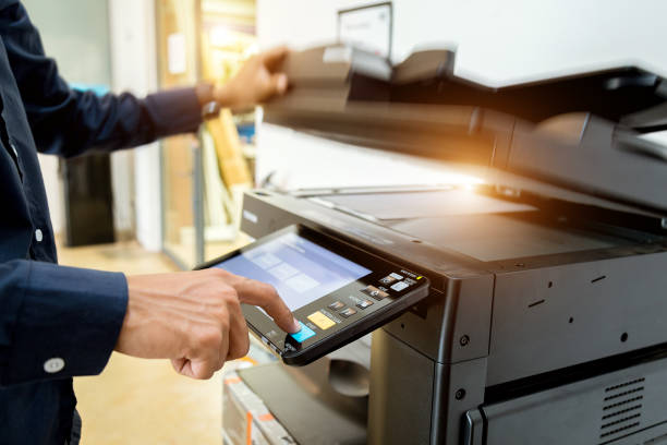 istock Bussiness man Hand press button on panel of printer, printer scanner laser office copy machine supplies start concept. 1043634430