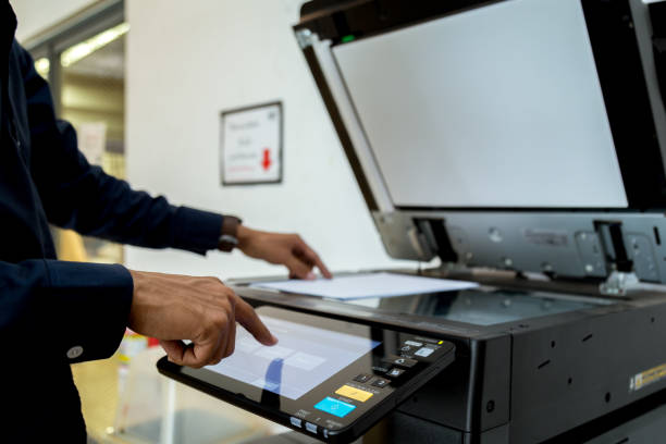 istock Bussiness man Hand press button on panel of printer, printer scanner laser office copy machine supplies start concept. 1043634736