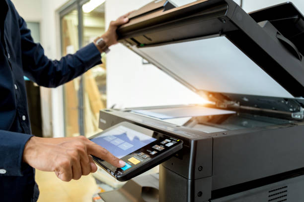 istock Bussiness man Hand press button on panel of printer, printer scanner laser office copy machine supplies start concept. 1043635088