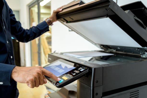 istock Bussiness man Hand press button on panel of printer, printer scanner laser office copy machine supplies start concept. 1043636860