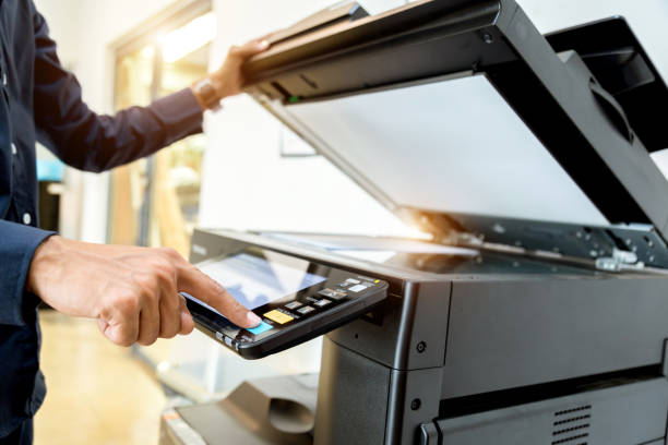 istock Bussiness man Hand press button on panel of printer, printer scanner laser office copy machine supplies start concept. 1043636962