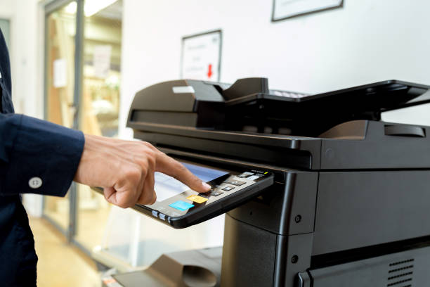 istock Bussiness man Hand press button on panel of printer, printer scanner laser office copy machine supplies start concept. 1043638016