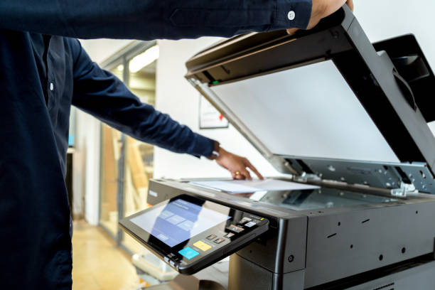 istock Bussiness man Hand press button on panel of printer, printer scanner laser office copy machine supplies start concept. 1043639022