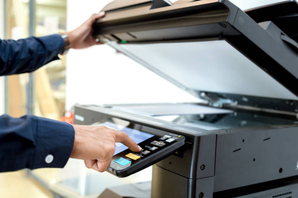 istock Bussiness man Hand press button on panel of printer, printer scanner laser office copy machine supplies start concept. 1043639032