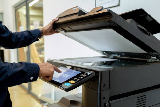 istock Bussiness man Hand press button on panel of printer, printer scanner laser office copy machine supplies start concept. 1043639080