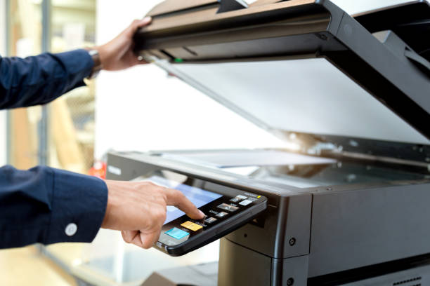 istock Bussiness man Hand press button on panel of printer, printer scanner laser office copy machine supplies start concept. 1043639108