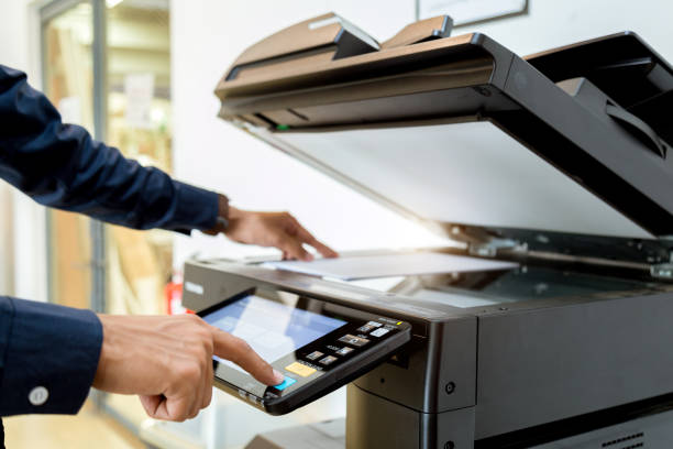 istock Bussiness man Hand press button on panel of printer, printer scanner laser office copy machine supplies start concept. 1043639202
