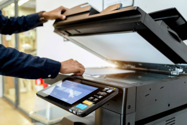 istock Bussiness man Hand press button on panel of printer, printer scanner laser office copy machine supplies start concept. 1043639352