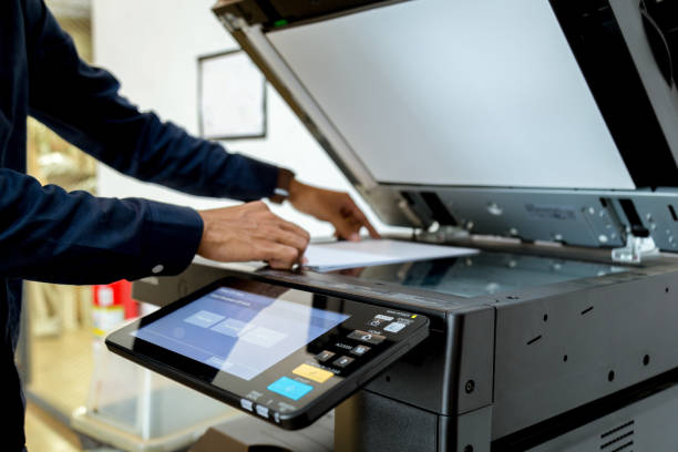 istock Bussiness man Hand press button on panel of printer, printer scanner laser office copy machine supplies start concept. 1043639378