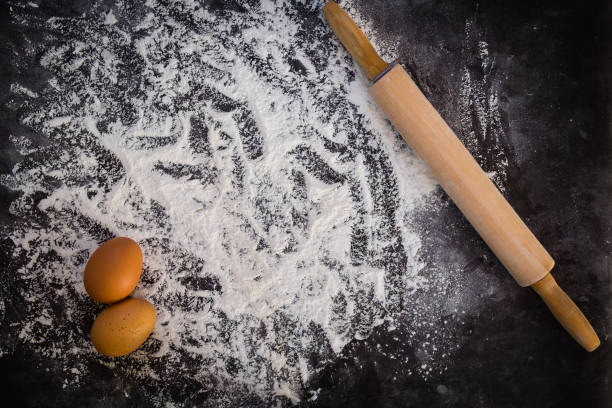 istock Baking background with the rolling pin with flour. On the dark table. Free space for text . Top view 1043643872