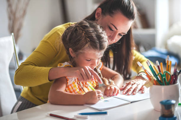 istock Young mother helping daughter with homework 1043644916