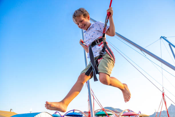 istock Smilling excited boy jumping on a trampoline with insurance. 1043648338