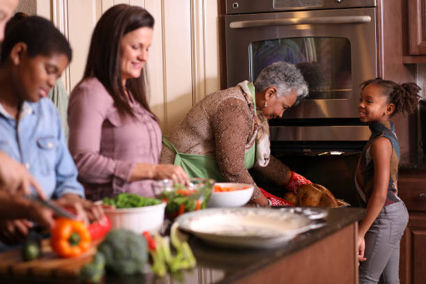 istock Diverse family in home kitchen cooking Thanksgiving dinner. 1043648860