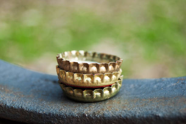 Three beer bottle metal caps on a bench