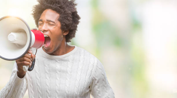 istock Young handsome afro american black man shouting through megaphone 1043656368