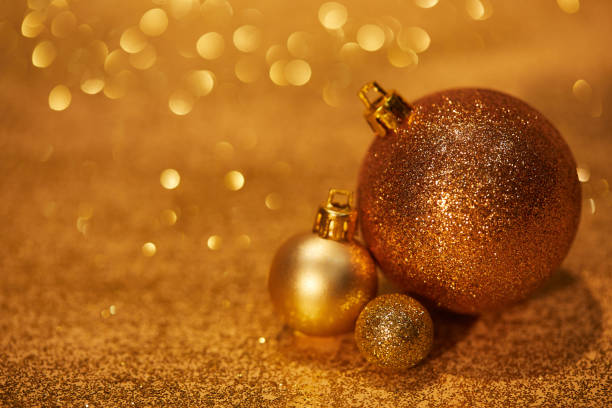 golden shiny decorative christmas balls on tabletop with sequins