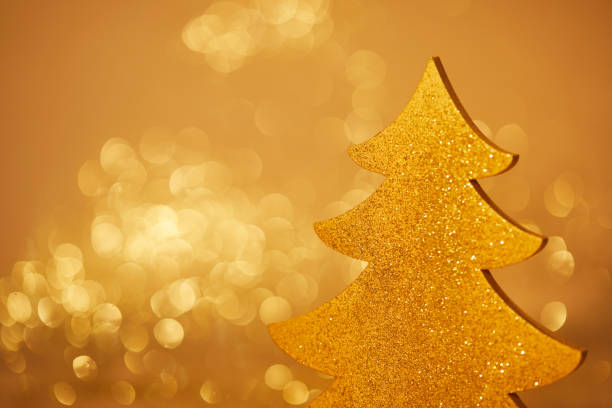 istock golden glittering christmas tree for decoration on blurred background 1043657518