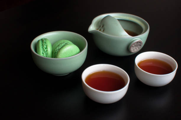 istock Cup of tea with french macaroon on dark background 1043657736