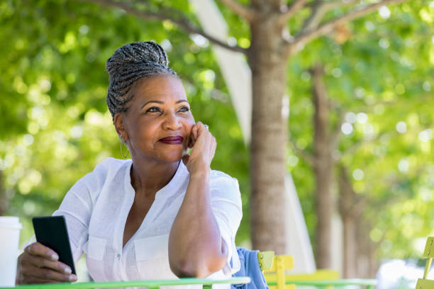 istock Senior woman daydreams while in park 1043661862