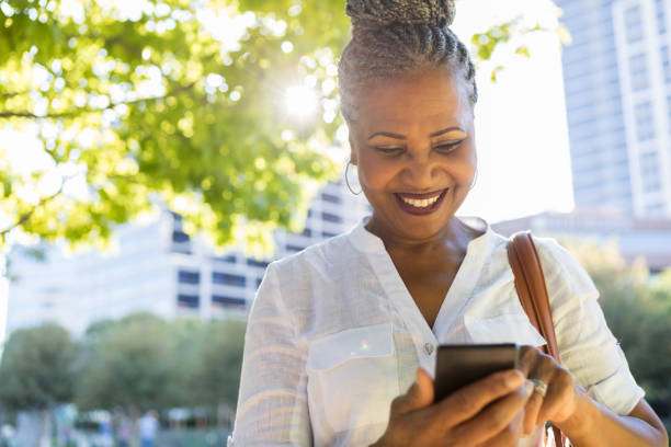 istock Smiling senior woman uses smartphone 1043661928