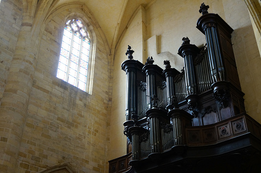 black church organ high up at the wall of an old chruch, bright church window