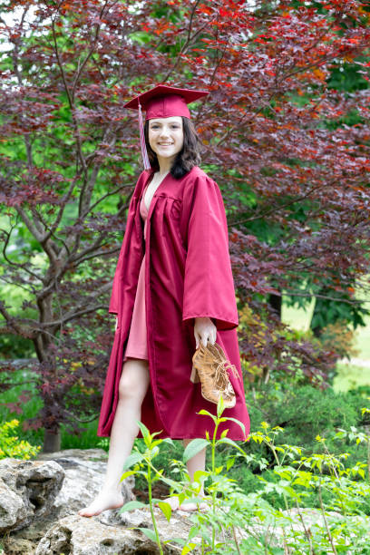 Eighteen Year Old Woman Enjoys a Walk in the Park after Graduation stock photo