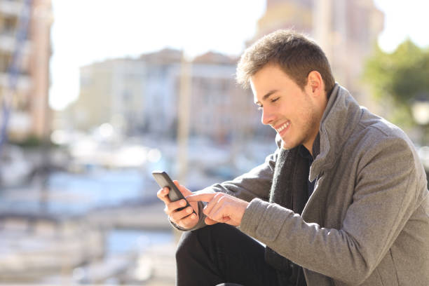 istock Man using a smart phone in winter in a coast town 1043708076