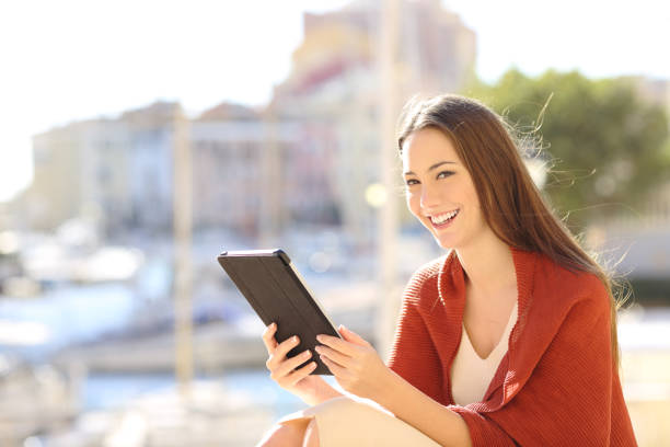 istock Woman looking at camera holding a tablet 1043708212