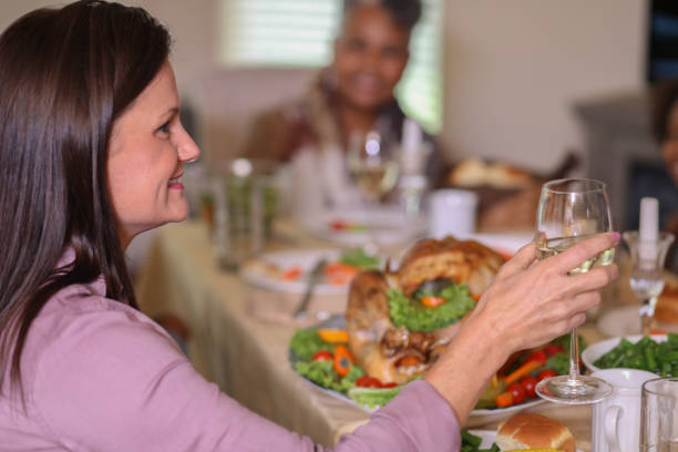 istock Diverse family at dining table eating Thanksgiving dinner. 1043710074