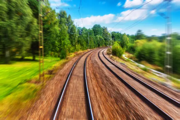 Train driver cabin view of the railroad tracks in summer with motion blur effect