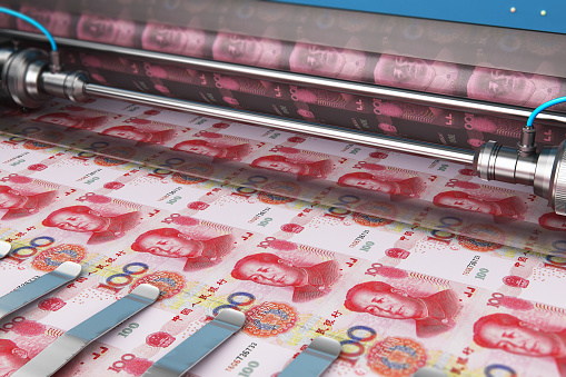 Business success, finance, banking, accounting and making money concept: printing 100 Chinese yuan money paper cash banknotes on print machine in typography