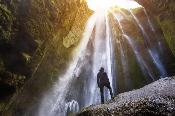 Photo of Gljufrabui waterfall in South Iceland,  adventurous traveller standing in front of the stream cascading into the gorge or canyon, hidden Icelandic landmark, inspirational landscape