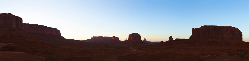Panoramic shot of the majestic landscape at John Ford's Point in Monument Valley Navajo Tribal Park at sunset in Arizona, USA. Multiple files stitched.