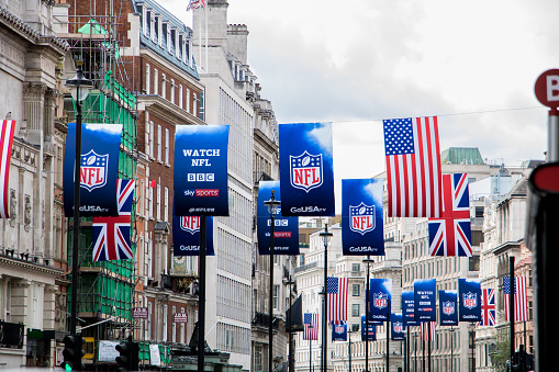 The Grand Hotel London, UK in Trafalgar Square with British flays flying in the wind and backlit by the late day sun.