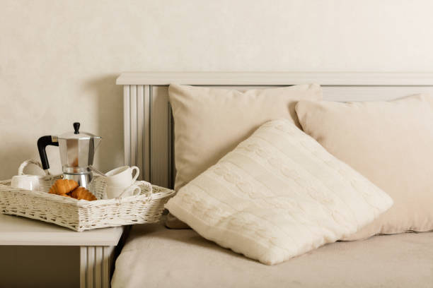 istock Breakfast in bed. On a white wicker tray there is a coffee maker, coffee white cups and croissants. 1043731560