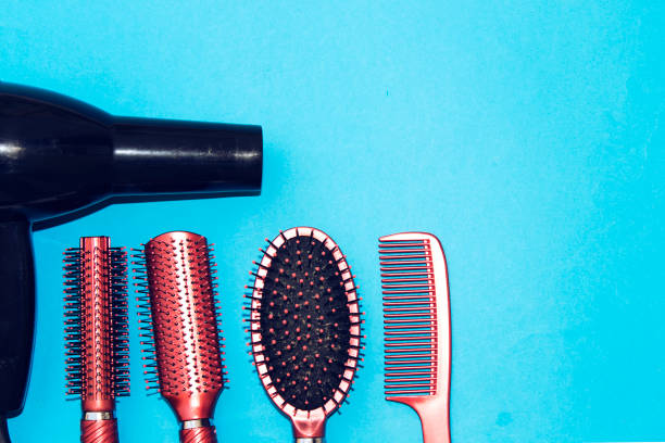 istock Professional hairdressing tools and black dryer isolated on blue  background with copy space 1043734892